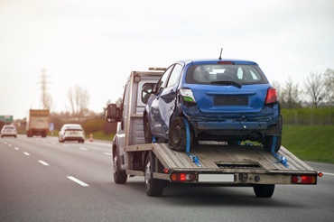Car loaded onto a flatbed tow truck