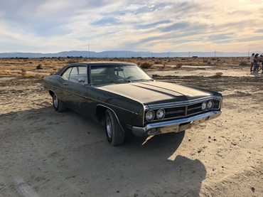 Older running car parked outdoors